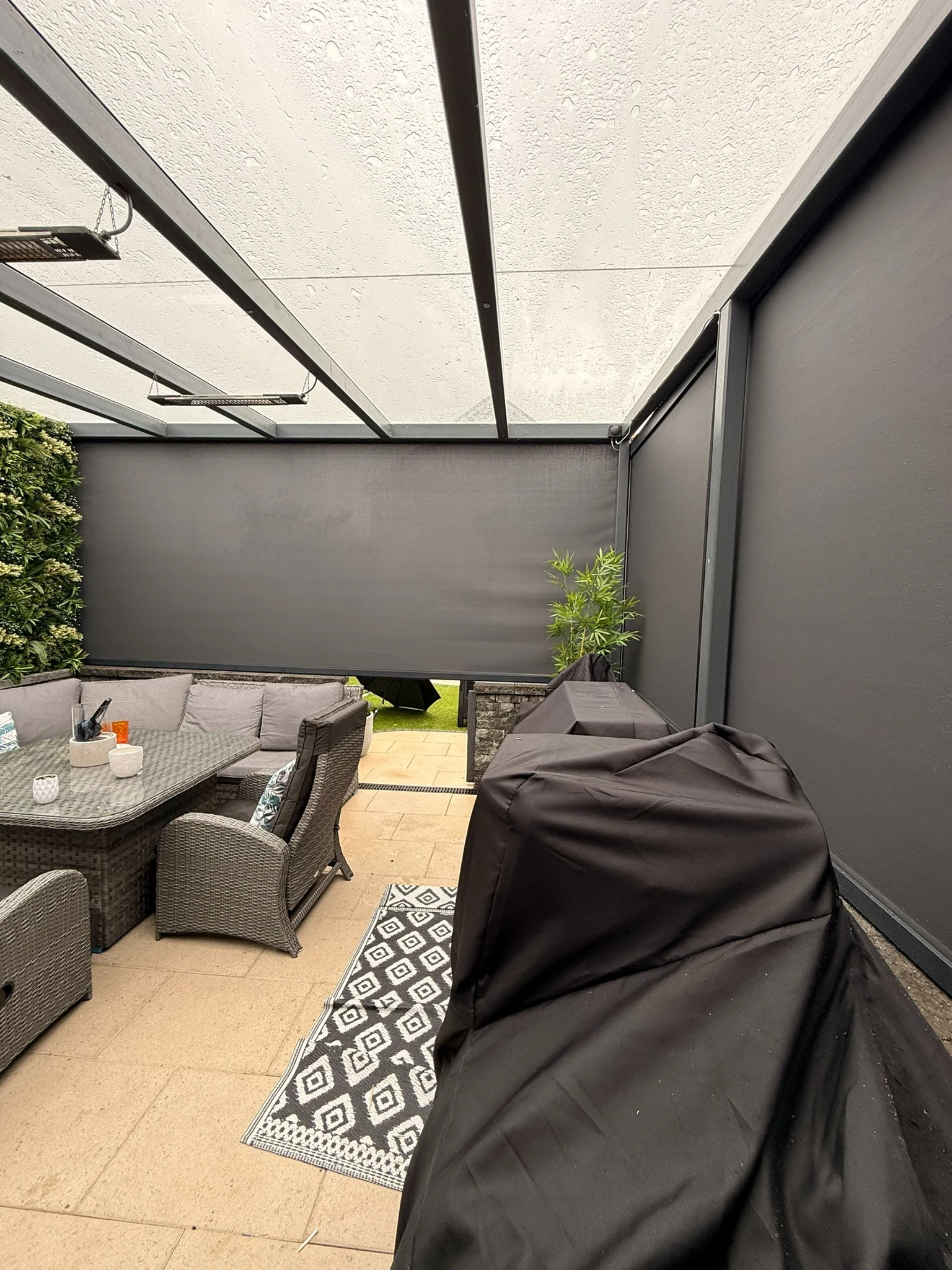 Large dark ZIP screens enclosing openings around a brick commercial outdoor area in Ireland